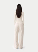 back view of a cream-colored outfit on a white background