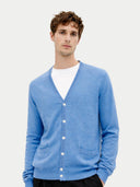 close up front view of man wearing a blue v-neck cardigan with pockets on a white background #color_blue
