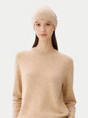 Woman wearing a beige beanie hat and sweater against a white background #color_beige