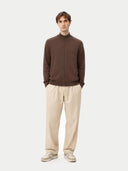 Man wearing a brown zip-up sweater and beige pants on a white background  #color_cocoa