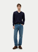 front view of a man wearing a navy sweater and blue jeans on a white background #color_navy-blazer