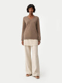 front view of a Woman wearing a brown sweater and beige pants on a white background #color_taupe