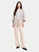 Woman wearing a beige jacket and pants on a white background #color_dawn-blue