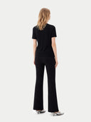 back view of a woman wearing a black outfit on a white background #color_black