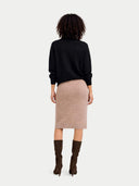 back view of person wearing a black sweater and beige skirt on a white background #color_black