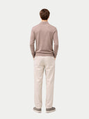 back view of a man wearing a light brown sweater and white pants on a white background #color_taupe