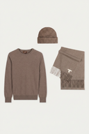 A three-piece knit winter set in a warm taupe-brown color, including a crewneck sweater, a ribbed beanie, and a fringed scarf with a small white embroidered letter T, displayed on a light gray background. #color_taupe
