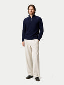 Man wearing a navy half-zip sweater and beige pants on a white background #color_navy-blazer