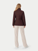 back view of a woman wearing a brown quilted jacket and beige pants on a white background #color_vineyard-wine