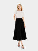 Woman wearing a white top and black skirt on a white background  #color_black