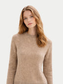 Woman wearing a beige sweater on a light background #color_warm-grey