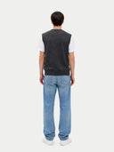 back view of a person wearing a dark gray vest over a white shirt and light blue jeans on a white background #color_charcoal