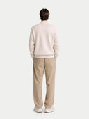 back view of a Person wearing a beige sweater and pants on a white background #color_marshmallow