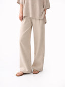 Person wearing beige pants and a matching top on a white background #color_biscotti