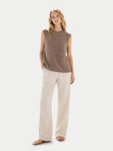 Woman wearing a brown sleeveless top and beige pants on a white background #color_taupe
