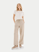 Woman wearing a white t-shirt and beige pants on a white background #color_taupe