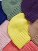 Stack of colorful knit hats in various patterns and colors.