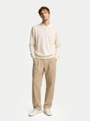 Man wearing a white sweater and beige pants on a white background #color_marshmallow
