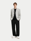 Man wearing a checkered blazer over a black shirt with black pants on a white background #color_off-white