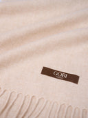 Close-up of a beige blanket with a Gobi Organic label. #color_beige