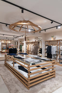 Inside a GOBI store: a wooden display table of folded knitwear under a round timber chandelier