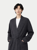 Man wearing a dark gray robe against a white background
