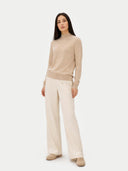 front view of a Woman wearing a beige sweater and cream pants on a white background #color_beige