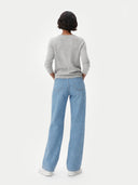 back view of a person wearing light blue jeans and a gray sweater on a white background #color_dawn-blue