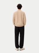 back view of a person wearing a beige sweater and black pants on a white background #color_warm-grey