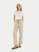 front view of a woman wearing a white t-shirt and beige pants on a white background #color_almond