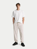 Person wearing a white t-shirt and beige pants on a white background #color_black