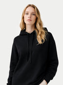Woman wearing a black hoodie against a plain background #color_black