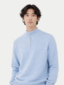 Man wearing a light blue cashmere sweater against a white background.