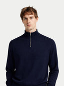 Man wearing a navy blue quarter-zip sweater on a light gray background #color_navy-blazer