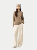 front view of a woman wearing a brown sweater, beige beanie, and white pants on a light gray background #color_taupe