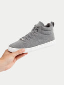 Gray high-top sneaker held by a hand on a white background  #color_stone-gray