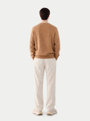 back view of a person wearing a brown sweater and white pants on a plain background #color_sheepskin