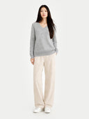 front view of a Woman wearing a gray sweater and white pants on a white background #color_vapor-blue