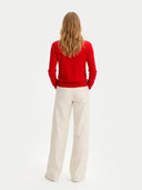 back view of a red sweater and beige pants on a white background #color_racing-red
