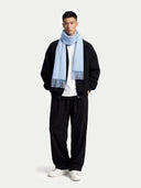 Man wearing a black jacket, white shirt, black pants, and a light blue scarf on a white background #color_light-blue