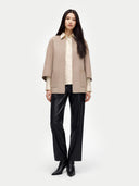 Person wearing a beige coat, white shirt, black pants, and black boots on a white background #color_taupe