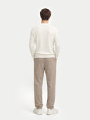 back view of a Person wearing a white sweater and beige pants on a white background #color_marshmallow