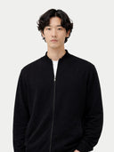 Man wearing a black zip-up cardigan against a white background  #color_black