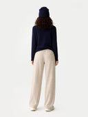 back view of a navy sweater and beige pants on a white background #color_india-ink