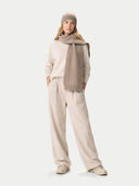 Woman wearing a beige sweater, scarf, and hat on a white background #color_taupe