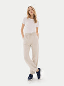 Woman wearing a white t-shirt and beige pants on a white background  #color_navy