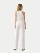 back view of Woman wearing a white jumpsuit on a white background #color_whisper-white