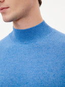 close up of a blue mock neck sweater worn by man on a white background #color_blue