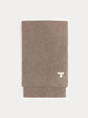 Folded brown blanket with a white logo on a light gray background #color_taupe
