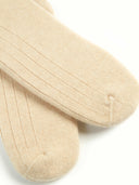 close up of beige socks with patterns on a light gray background #color_beige